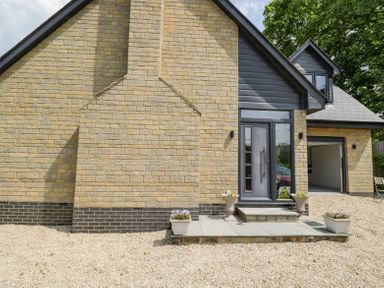 Exterior of a house with a gravel driveway stone steps and flower pots at Greystones in Upton St Leonards