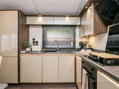 A kitchen with cabinets a sink toaster coffee machine and a gas stove at 43 Pony Meadow in Troutbeck Bridge