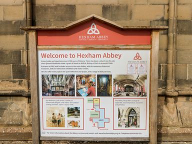 An information board welcoming visitors to Hexham Abbey with details about history cafe shop and services at Hexham Abbey in Hexham