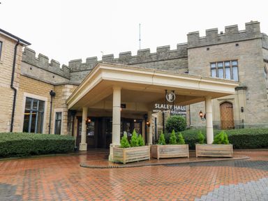 Entrance of a stone building with pillars and a covered porch at Slaley Park Villa in Hexham