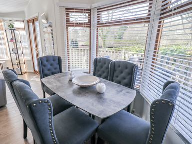 A dining room with a table and chairs at JacMar Lodge, 14 Applethwaite, Limefitt Park near Windermere