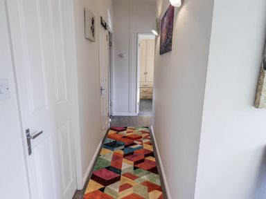 A hallway with a colorful rug and doors at JacMar Lodge 14 Applethwaite Limefitt Park near Windermere