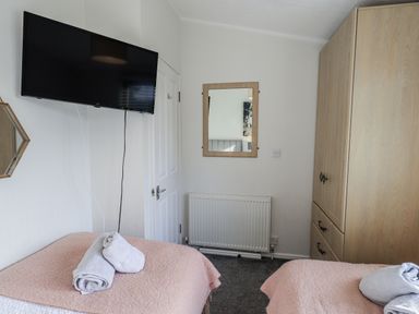 A bedroom with a television and a wardrobe at JacMar Lodge, 14 Applethwaite, Limefitt Park near Windermere