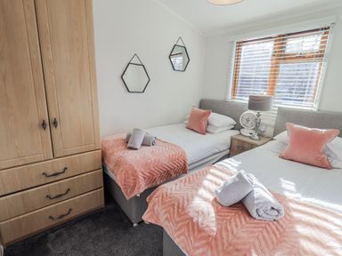 A bedroom with twin beds and a wardrobe at JacMar Lodge, 14 Applethwaite, Limefitt Park near Windermere