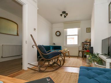 A living room with a rocking chair sofa coffee table and television at 26 High West in Weymouth