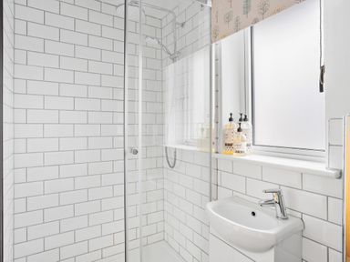 A bathroom with a shower area and a sink under a frosted window at The Farm Office in Bampton Devon