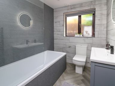 A bathroom with bathtub toilet sink and window at Pondarosa in Newbridge-On-Wye
