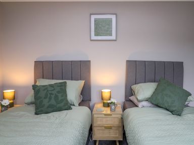 A bedroom with two single beds a bedside table and lamps at Pondarosa in Newbridge-On-Wye