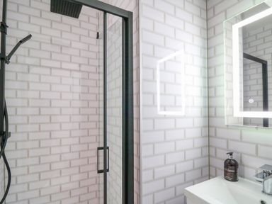 A bathroom with a shower enclosure a sink and an illuminated mirror at Pondarosa in Newbridge-On-Wye