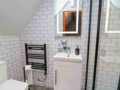 A bathroom with a white sink cabinet black towel rack and a toilet at Pondarosa in Newbridge-On-Wye