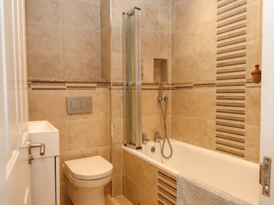 A bathroom with a toilet bathtub and a small sink at 14 Burgh Island Causeway in Bigbury-On-Sea