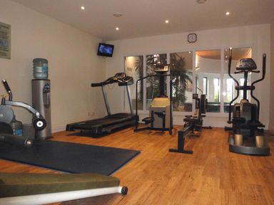 A gym room with exercise machines a treadmill a rowing machine and a water cooler at 14 Burgh Island Causeway in Bigbury-On-Sea