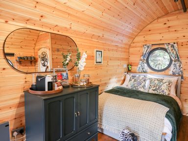 A bedroom with a bed pillows and a cabinet with a coffee machine and mirror at The Kites Nest in Pont-rhyd-y-groes near Pontrhydfendigaid Snowdonia