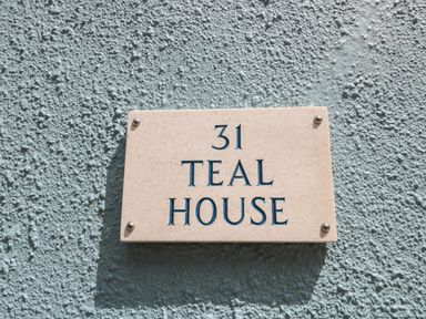 A house number plaque reading 31 teal house on a textured teal wall at Teal House in Lyme Regis