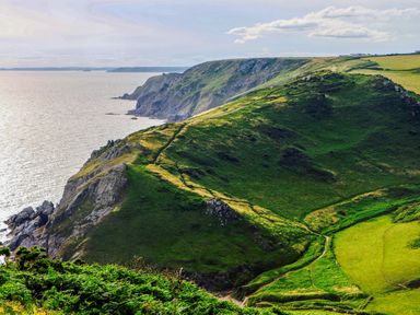 A coastline with cliffs and green hills overlooking the sea at 1 Camperdown Lodge in Salcombe