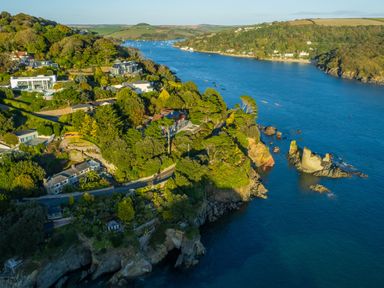 A coastal residential area with houses and trees along a river at 1 Camperdown Lodge in Salcombe