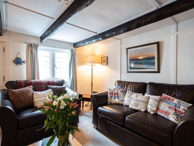A living room with two leather sofas a floor lamp and a framed picture at St Samson in Port Isaac