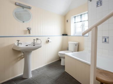 A bathroom with a pedestal sink toilet bathtub and tiled walls at St Samson in Port Isaac