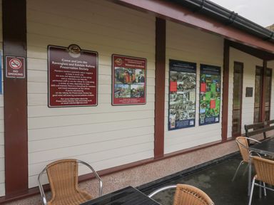 A wall with informational posters and no smoking sign beside outdoor tables and chairs at Dalegarth Hall Farm Cottage 1 Boot near Eskdale Green