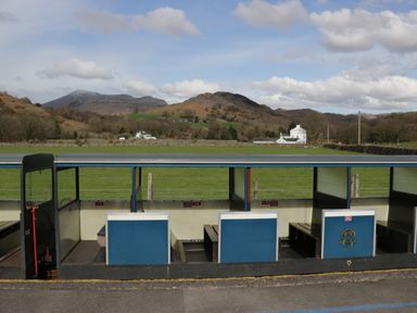 An open-air train carriage with blue and cream seats in a rural area with green fields and hills at Dalegarth Hall Farm Cottage 1 Boot near Eskdale Green