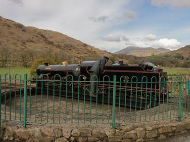 A miniature steam train with a person inspecting it on a turntable in a rural area with hills in the background at Dalegarth Hall Farm Cottage 1 Boot near Eskdale Green