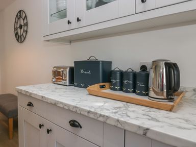 A kitchen countertop with a toaster bread box containers and an electric kettle at Dalegarth Hall Farm Cottage 1 Boot near Eskdale Green