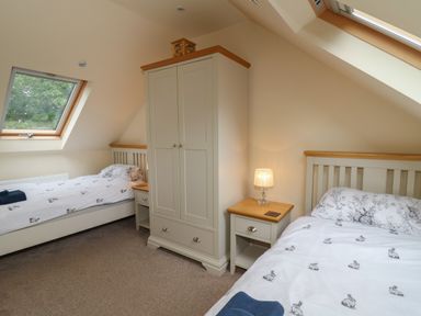 A bedroom with two single beds a wardrobe and bedside tables at Gelli Barn Near Llandeilo