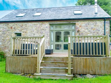 An outdoor area with deck and furniture at Gelli Barn Near Llandeilo