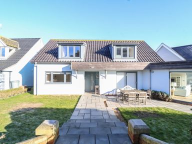 A two-story house with a front garden patio and outdoor dining table at Pebbles Southwold