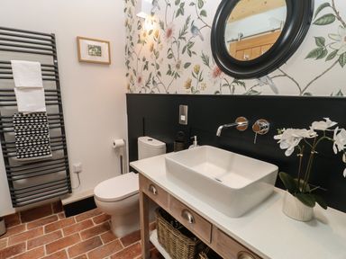 A bathroom with a toilet a sink and towels on a rack at The Bothy Riding Hills Riding Mill near Corbridge