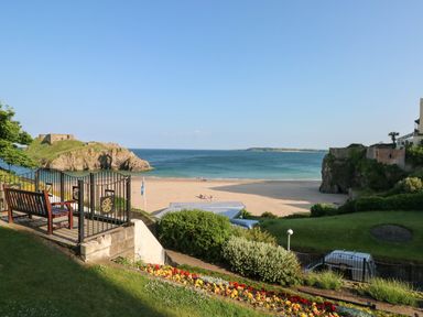 A beach view with benches flowers and a gate overlooking the sea at Flat 1 in Tenby
