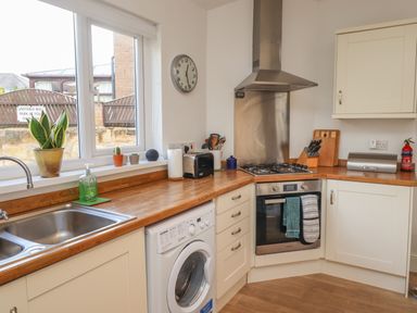 A kitchen with a sink washing machine oven stove and countertop items at White Feathers in Alnwick
