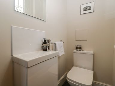 A small bathroom with a white sink and toilet and a towel on a rail at The Old Chapel in Dorstone near Hay-on-Wye
