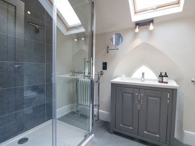 A bathroom with a shower cubicle and a sink cabinet under a skylight at The Old Chapel in Dorstone near Hay-on-Wye