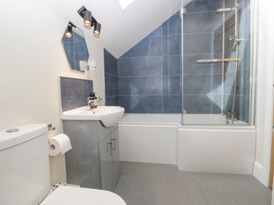 A bathroom with a toilet sink and bathtub with glass shower screen at The Old Chapel in Dorstone near Hay-on-Wye