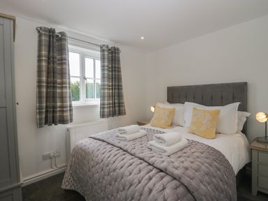 A bedroom with a double bed and folded towels on at Betty's Loft in Hawkshead
