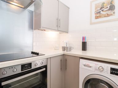 A kitchen corner with an oven hob kettle knife block and washing machine at Fell View Clappersgate near Ambleside