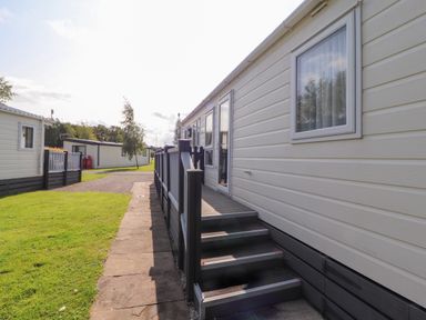 Exterior view of a mobile home with stairs and a small porch at 41 Grandma's Cottage South Lakeland Leisure Village near Carnforth