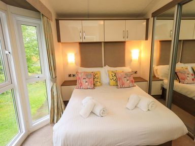 A bedroom with a bed and wardrobe at 41, Grandma's Cottage South Lakeland Leisure Village near Carnforth