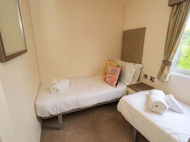 A bedroom with two single beds and a mirror at 41, Grandma's Cottage South Lakeland Leisure Village near Carnforth