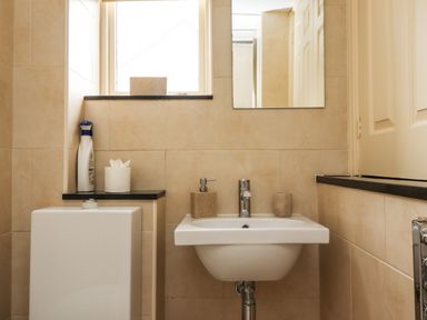 A bathroom with a sink mirror toilet and window at Cullernose Cottage Newton-by-the-Sea near Embleton