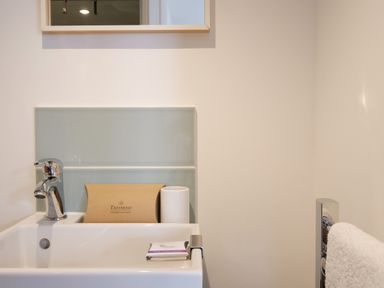 A bathroom sink with a silver faucet soap and a towel on a rack at Waves End in St Ives