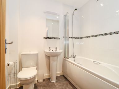 A bathroom with a toilet sink and bathtub with shower at Garras in Porthtowan