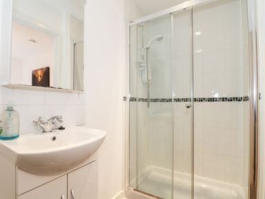 A bathroom with a sink and a glass shower enclosure at Garras in Porthtowan