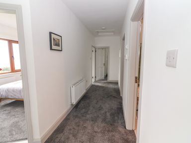 A hallway with gray carpet a radiator and doors leading to adjacent rooms at Gortnamona in Coolnaharragill Lower near Glenbeigh County Kerry