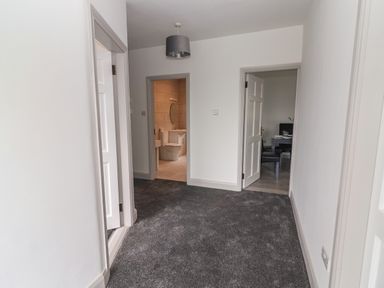 A carpeted hallway with doors leading to a bathroom and a dining area at Gortnamona in Coolnaharragill Lower near Glenbeigh County Kerry