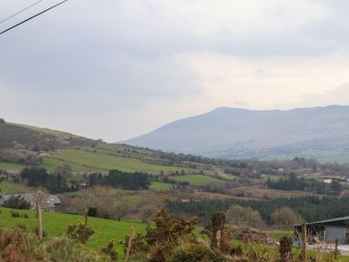 A rural landscape with green fields trees hills and a mountain in the background at Gortnamona in Coolnaharragill Lower near Glenbeigh County Kerry