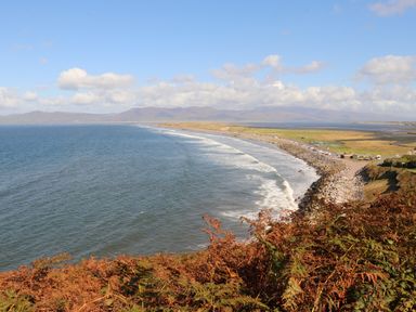 A coastline view with waves and a rocky shore with a grassy area and mountains in the background at Gortnamona Coolnaharragill Lower near Glenbeigh County Kerry