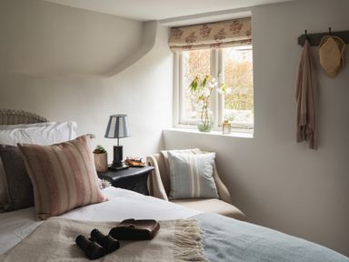A bedroom with a bed a bedside table and a chair near a window at Butterwell Cottage at Collihole in Chagford