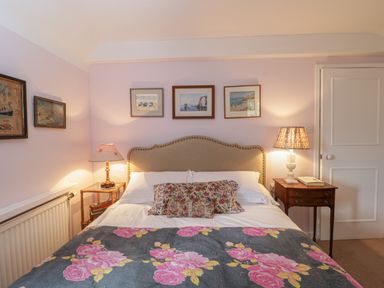 A bedroom with a bed pillow and lamps on side tables at Chalkpit Cottage in Blewbury